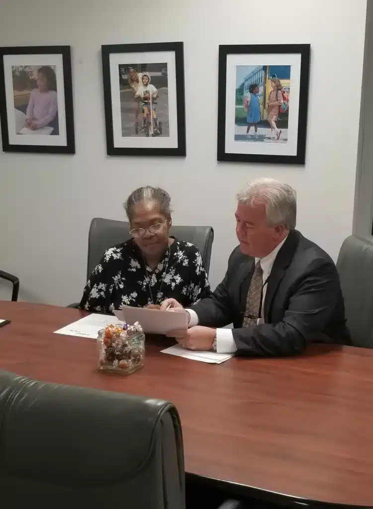 Photo of Ms. Kim Gatewood and Executive Director Eric Munson reviewing documents at the administrative office of the Governor’s Council on Developmental Disabilities.